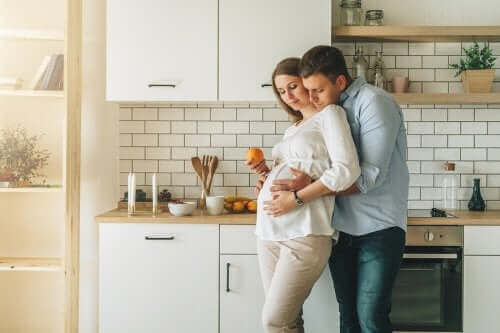 Une femme enceinte enlacée par son mari.