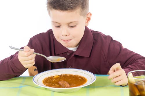 Un enfant qui mange une soupe.