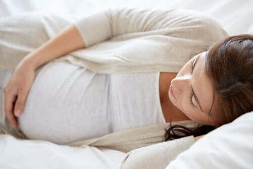 Une femme enceinte allongée sur le côté.