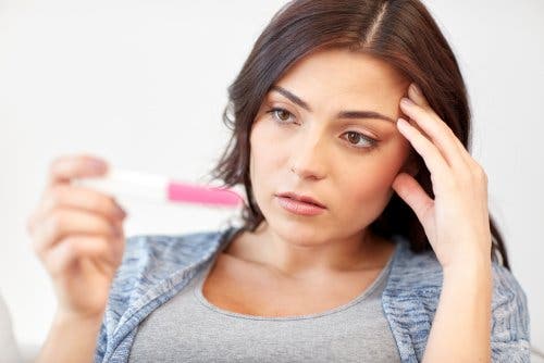 Une femme regardant un test de grossesse.