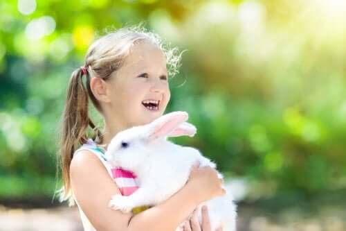 Une petite fille serre son lapin dans ses bras.