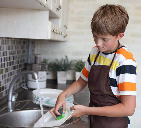 Un enfant faisant la vaisselle.