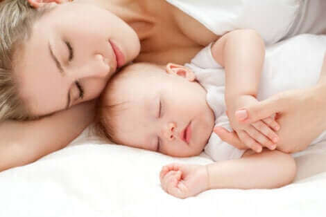 Une mère dormant avec son bébé.