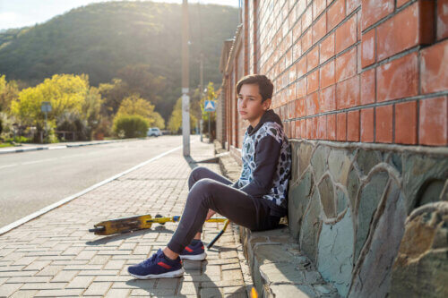 Un adolescent avec son skate qui ressent la solitude.