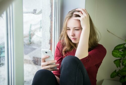 Une adolescente avec son portable sur les réseaux sociaux.