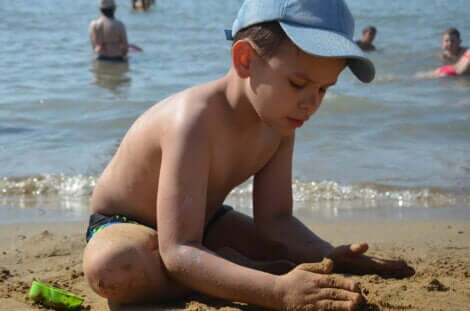 Un garçon qui joue dans le sable à la plage. 