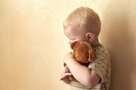 Un enfant qui fait un câlin à une peluche. 