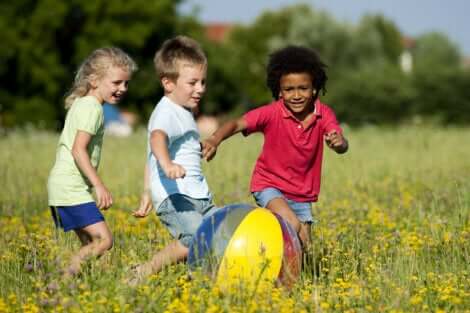 Trois enfants qui jouent avec un ballon.