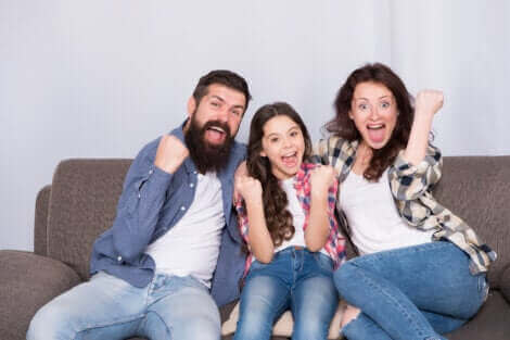 Une famille s'amusant sur leur canapé.