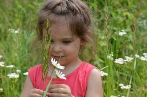 Une fille jouant avec des fleurs.