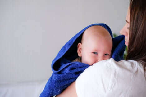 Un bébé sortant du bain dans une serviette.