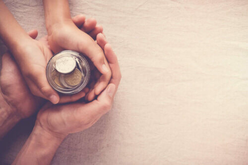 Un enfant avec une tirelire dans les mains.