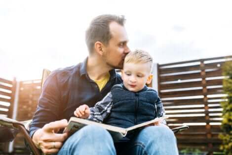 Un père qui lit un livre avec son enfant sur les genoux. 