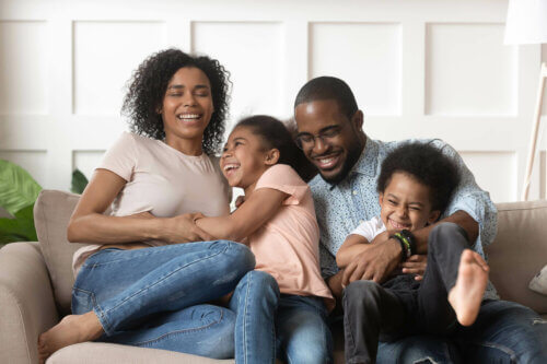 Une famille rit sur son canapé.