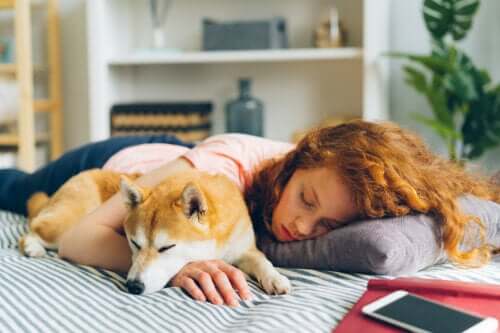 Une adolescente qui dort avec son chien. 