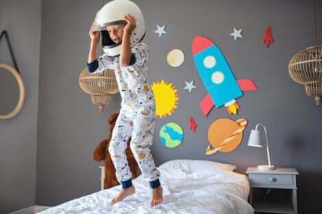 Un enfant qui saute sur son lit avec un casque sur la tête. 