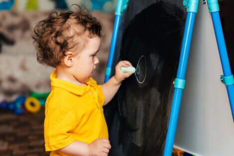 Un enfant qui écrit sur un tableau. 