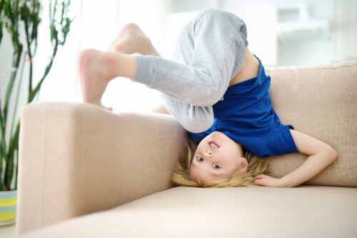 Un enfant impulsif faisant une roulade sur le canapé.