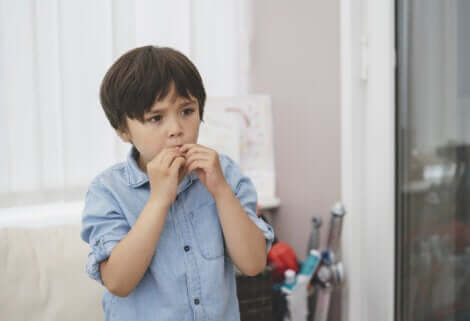 Un jeune enfant inquiet qui se mange les doigts. 