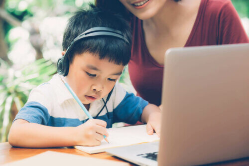Un enfant et sa mère en train d'écrire à l'ordinateur.
