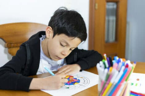 Un jeune garçon qui colorie un mandala. 