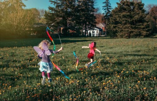 Des enfants courent au parc avec des déguisements de fée.
