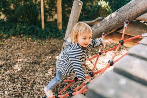 Le jeu libre d'une petite fille qui escalade au parc de jeux.