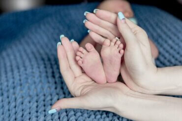 Les pieds d'un bébé et mains de sa mère.