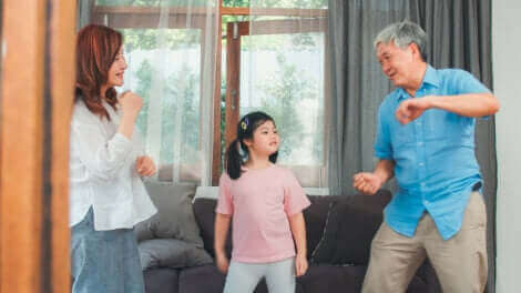 Des parents dansant avec leur fille.