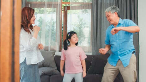 Une famille qui danse dans le salon.