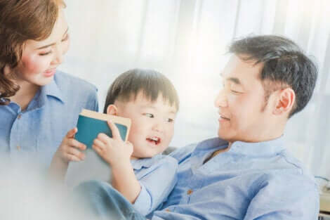 Un enfant qui lit avec ses deux parents. 