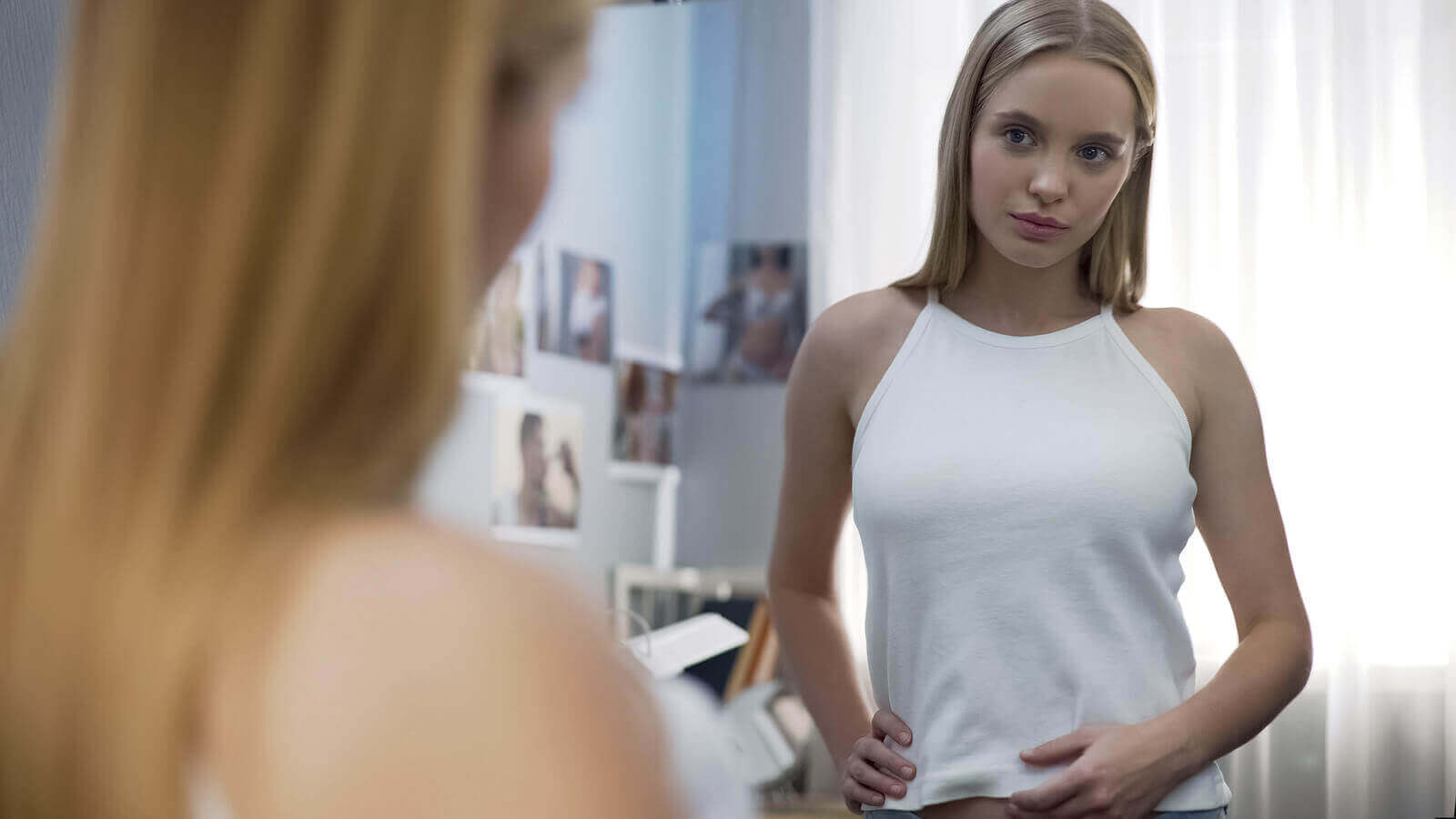 Une adolescente qui se regarde dans un miroir.
