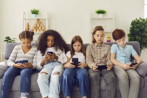 Cinq adolescents sur leur téléphone.