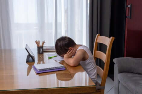 Un enfant fatigué qui fait ses devoirs. 