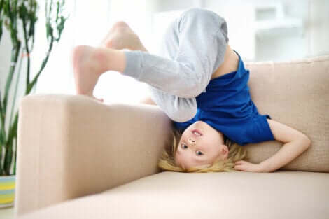 Un enfant qui se roule sur un canapé. 