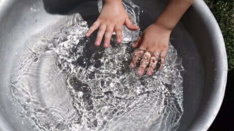 Un enfant qui met ses mains dans l'eau.