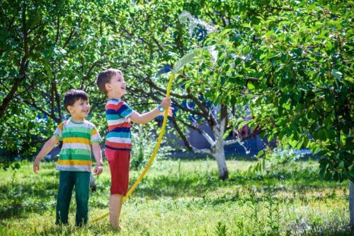 Des enfants arrosant les plantes du jardin.