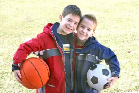 Deux enfants avec un ballon de football et de basket. 