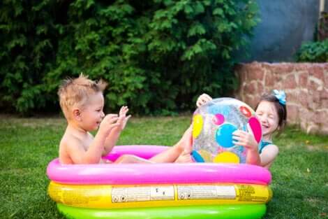 Deux enfants qui jouent dans une piscine. 