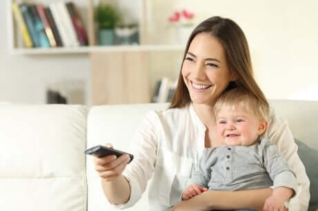 Une maman et son bébé devant la télévision.