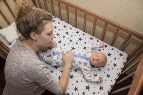 Une maman qui regarde son bébé dans son berceau.