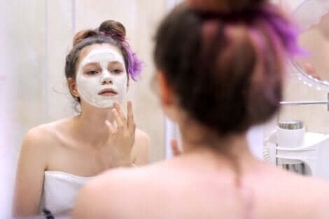 Une adolescente qui se fait un masque du visage. 
