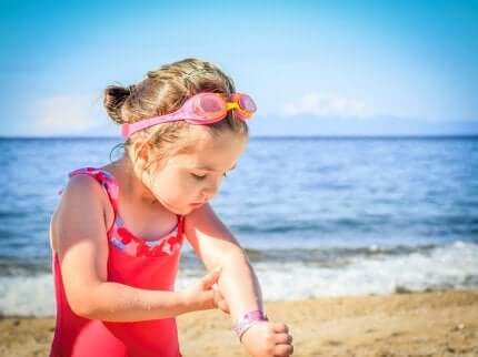 Une petite fille avec de la crème solaire.