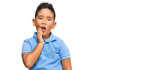 Un jeune garçon qui a mal aux dents.