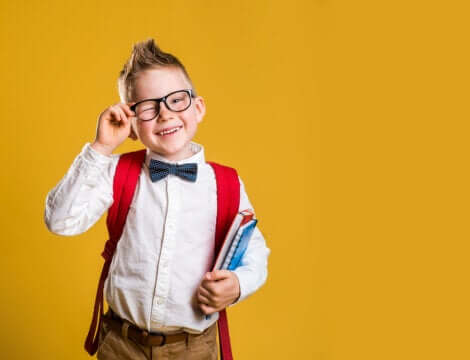 Un jeune garçon avec des lunettes et un nœud papillon.