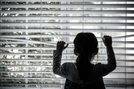 Une jeune fille qui regarde par la fenêtre. 