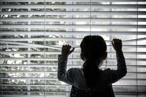 Une jeune fille qui regarde par la fenêtre.