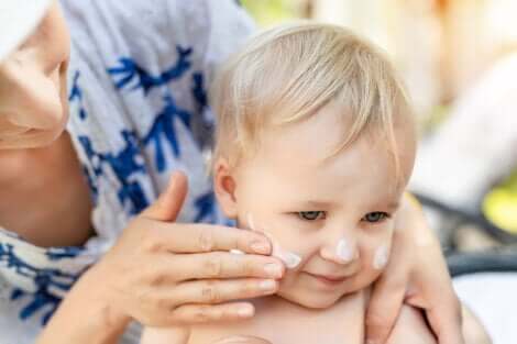 Application de crème solaire sur le visage d'un enfant. 