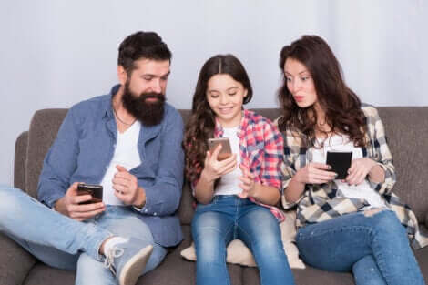 parents avec leur fille sur le téléphone