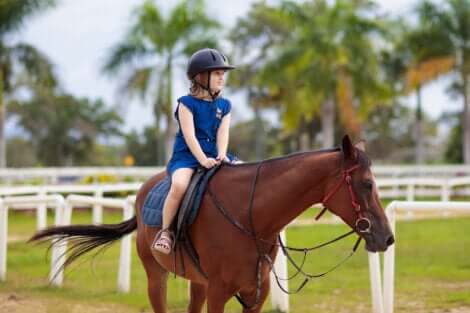 Une petite fille qui fait de l'équitation.
